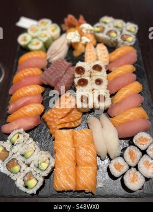 Gros plan d'une boîte remplie de sushi. Rouleaux californiens, saumon, avocat, thon et bien d'autres. Banque D'Images