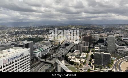 LOS ANGELES, CA, MAI 2023 : vue vers le nord depuis un grand bâtiment du centre-ville, à travers 110 et 101 autoroutes, vers des montagnes lointaines. Ciel couvert au-dessus Banque D'Images