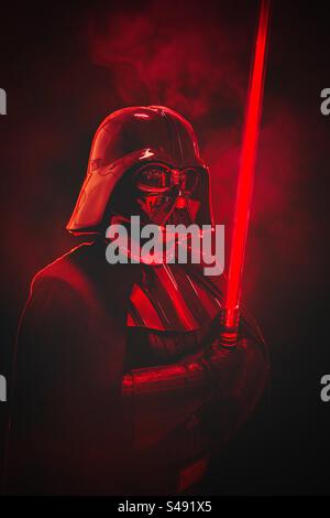 Portrait dramatique de Star Wars Darth Vader cosplay avec sabre laser rouge Banque D'Images