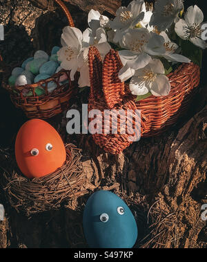 Oeufs dans les nids avec panier de fleurs en forme de lapin Banque D'Images