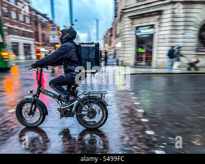 Chauffeur de livraison de restauration rapide sur vélo électrique dans le centre-ville de Leeds Banque D'Images