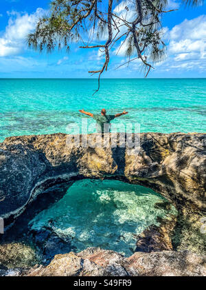 Un homme est assis près de l'océan dans la baie de Tarpum, Eleuthera, Bahamas le 12 novembre 2023. Banque D'Images