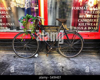 Vélo de style ancien à l'extérieur de la boutique publicité Armstrong & son vêtements vintage, tweeds, cachemire, kiltwear, Grassmarket Edinburgh Écosse Banque D'Images