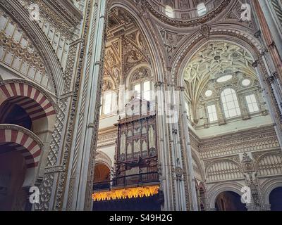 Orgue à tuyaux parmi les murs et les arches ornés de blanc dans la partie chrétienne de la mosquée-cathédrale de Córdoba, Espagne. Banque D'Images