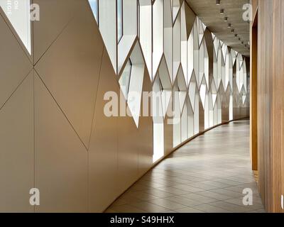 Un couloir incurvé éclairé par des fenêtres intéressantes à la succursale principale de la Bibliothèque publique de Calgary. Banque D'Images