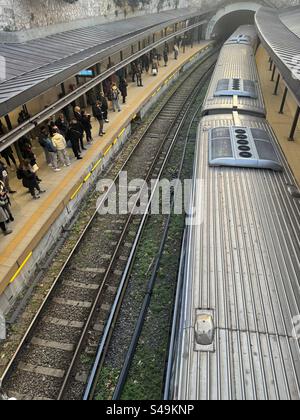 Train arrivant à la station de métro Monastiraki à Athènes, Grèce, avec des gens qui attendent sur le quai. Banque D'Images
