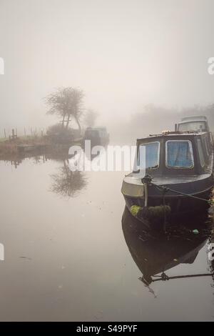 Des bateaux étroits amarrés par un matin brumeux sur le canal de Leeds et Liverpool à Adlington dans le Lancashire Banque D'Images