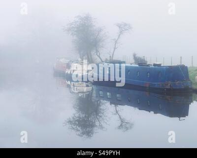 Des bateaux étroits amarrés par un matin brumeux sur le canal de Leeds et Liverpool à Adlington dans le Lancashire Banque D'Images