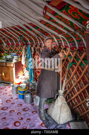 Bayan Olgii, la Mongolie, le 29 septembre 2015 : Mongoilian nomades kazakhs man helping out dans la fabrication du fromage Banque D'Images