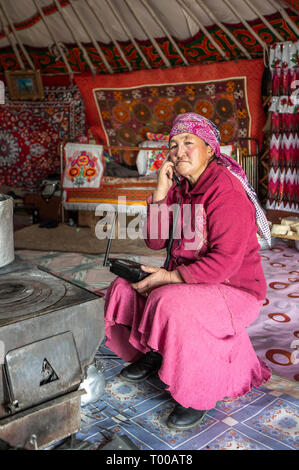 Bayan Olgii, la Mongolie, le 29 septembre 2015 : Mongoilian femme nomade kazakh sur un téléphone dans sa maison yourte Banque D'Images