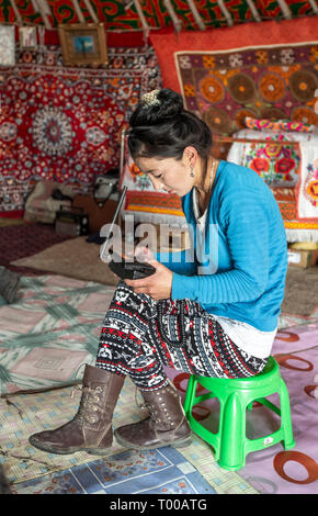 Bayan Olgii, la Mongolie, le 29 septembre 2015 : Mongoilian femme nomade kazakh en attente d'un appel téléphonique à la maison yourte Banque D'Images