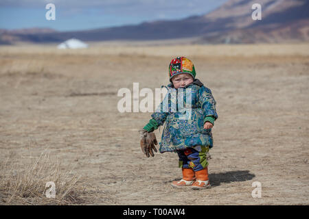 Bayan Ulgii, la Mongolie, le 29 septembre 2015 : nomade kazakh mongol Garçon jouant dans un paysage de l'ouest de la Mongolie Banque D'Images