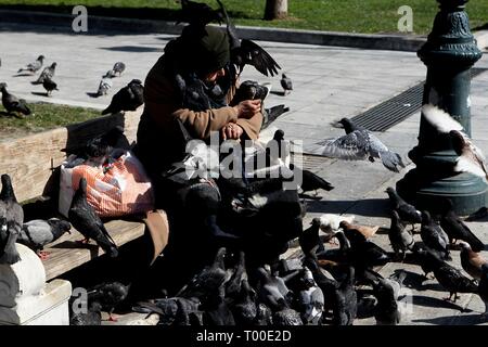 Femme sans-abri nourrir les pigeons dans la place Syntagma, Athènes Grèce Banque D'Images