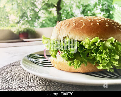 Close-up composé de délicieux burgers sur table en bois et terrasse accueil fond. Banque D'Images