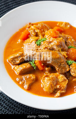 Concept alimentaire classique français le ragoût de veau Marengo de veau dans une plaque en céramique blanche with copy space Banque D'Images