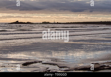 À l'aube, les nuages reflètent dans le sable humide de la plage avec voile et la côte Banque D'Images