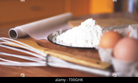 Ingrédients pour la cuisson du pain maison. Les oeufs, la farine. Fond de bois, vue de côté. Soft focus et de la lumière Banque D'Images