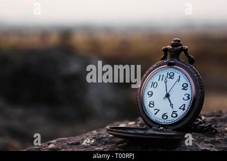 Montre Analogique Quartz pocket conservés sur un rocher. Banque D'Images