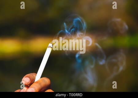 Main tenant une cigarette à fumer Banque D'Images