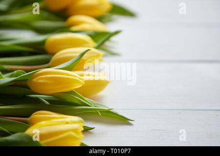 Composition de tulipes fraîches placés dans la rangée de table rustique en bois blanc Banque D'Images