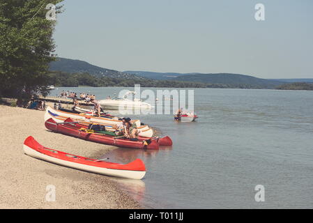 Locations de personnes sur la plage du Danube avec Red Canoe Banque D'Images