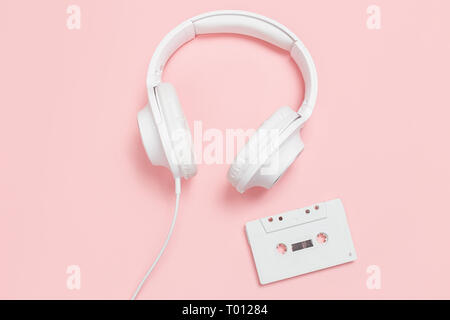 Cassette et casque blanc sur fond rose. Partie 90s concept. Banque D'Images