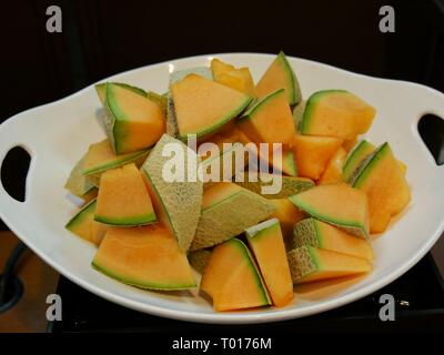 Tranches de melon de cantaloup disposées dans une assiette ovale ronde Banque D'Images