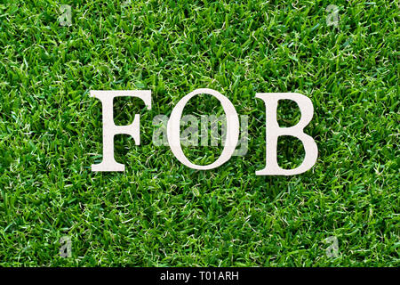Lettre en bois porte-parole (abréviation de free on board) sur fond d'herbe verte artificielle Banque D'Images