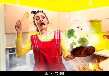 Crazy ménagère dans la cuisine de l'aire de feu sur le brocoli Banque D'Images