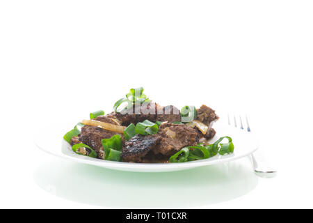 Foie frit avec des oignons dans une assiette sur un livre blanc Banque D'Images