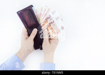 Sac à main avec de l'argent dans les mains sur un fond blanc Banque D'Images