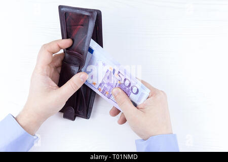 Sac à main avec de l'argent dans les mains sur un fond blanc Banque D'Images