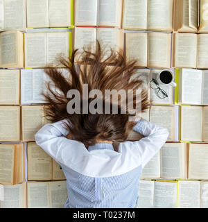 Une jeune fille se prépare pour les examens. Beaucoup de livres. Vue d'en haut. Concept pour la Journée mondiale du livre, le style de vie, d'étude, de l'éducation Banque D'Images