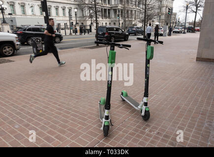 Les cavaliers attendent les scooters électriques de chaux, Eisenhower Executive Office Building in backgrouns. LimeBike, une de plusieurs sociétés en scooter dockless DC. Banque D'Images