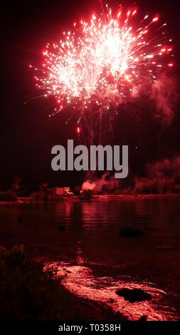 Burst brillant de Fireworks avec reflets dans l'eau Banque D'Images