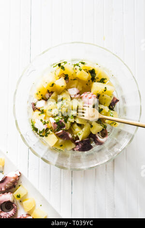 Salade de poulpes et de pommes de terre avec un style élégant, des morceaux de poulpe bouilli et les pommes sur un plat rectangulaire avec un élégant,fourche d'or plus d'un woo Banque D'Images