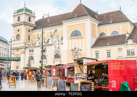 Marché de Noël avec la Freyung Schottenkirche Eglise catholique à l'arrière, centre-ville de Vienne, Autriche. Banque D'Images