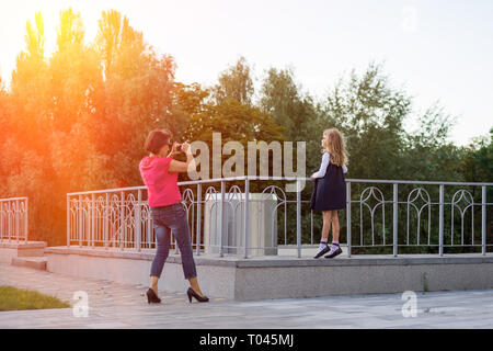 Mère et fille, l'amour et l'amitié, maman fait une photo de la jeune fille pour échanger des Instagrams Banque D'Images