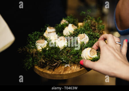 La main de femme est prise d'un seul morceau d'un plat exotique au cours d'un événement d'entreprise le dîner de luxe Banque D'Images