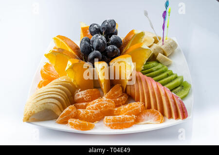 Mélange de fruits en plaque blanche isolé sur fond blanc - Alimentation saine style Banque D'Images