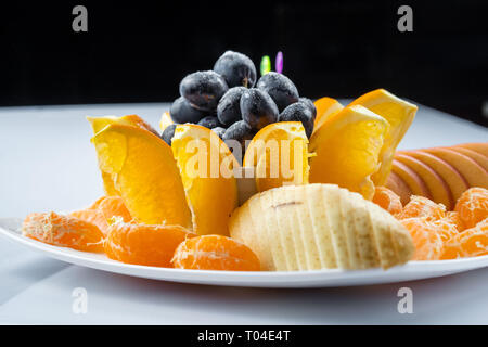 Mélange de fruits en plaque blanche isolé sur fond blanc - Alimentation saine style Banque D'Images