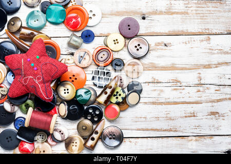 Bobines de fils et de boutons sur table en bois Banque D'Images