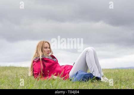 Jeune femme assise seule on meadow Banque D'Images