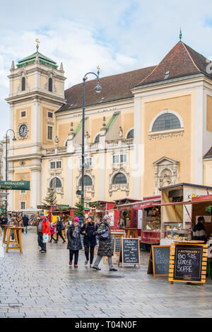 Marché de Noël avec la Freyung Schottenkirche Eglise catholique à l'arrière, centre-ville de Vienne, Autriche. Banque D'Images