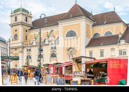 Marché de Noël avec la Freyung Schottenkirche Eglise catholique à l'arrière, centre-ville de Vienne, Autriche. Banque D'Images