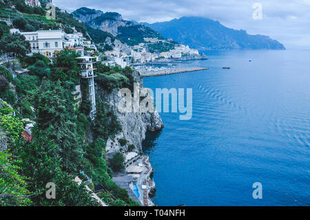 Les bâtiments donnant sur la falaise, avec la ville d'Amalfi en arrière-plan, Côte d'Amalfi, Italie Banque D'Images