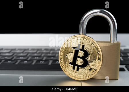 Bitcoin physique avec un cadenas sur un ordinateur portable Clavier d'ordinateur. La cyber sécurité cryptocurrency anglais Abstract concept. Copie de l'espace sur la gauche. Banque D'Images