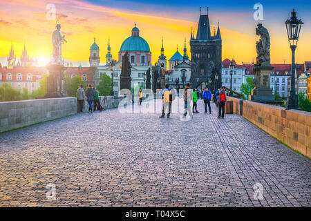 PRAGUE, RÉPUBLIQUE TCHÈQUE - le 24 avril 2017 : les touristes et les photographes de marcher sur le pont Charles au lever du soleil coloré, Prague, République Tchèque, Europe Banque D'Images