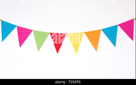 Drapeaux en papier suspendus colorés sur fond de mur blanc, articles de décor pour la fête, festival, événement célébrer Banque D'Images