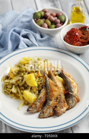 Chicharros fritos, Portugal traditionnel chinchard pané rôti avec du chou, des poissons, de pommes de terre et petits pois stew Banque D'Images